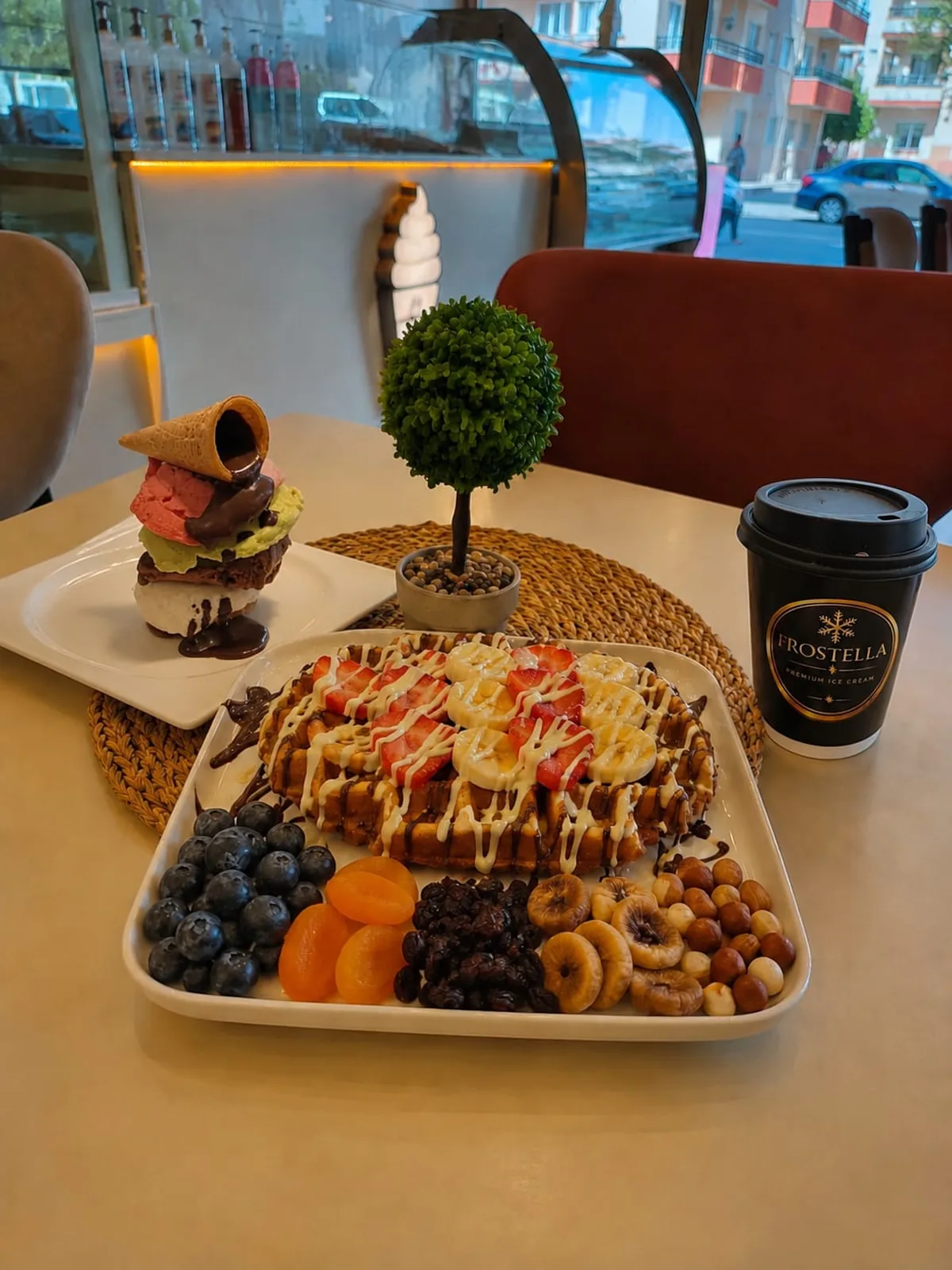 Frostella Royal Waffle: çilekli muzlu waffle, yanında kuru meyve ve fındık tabağı
